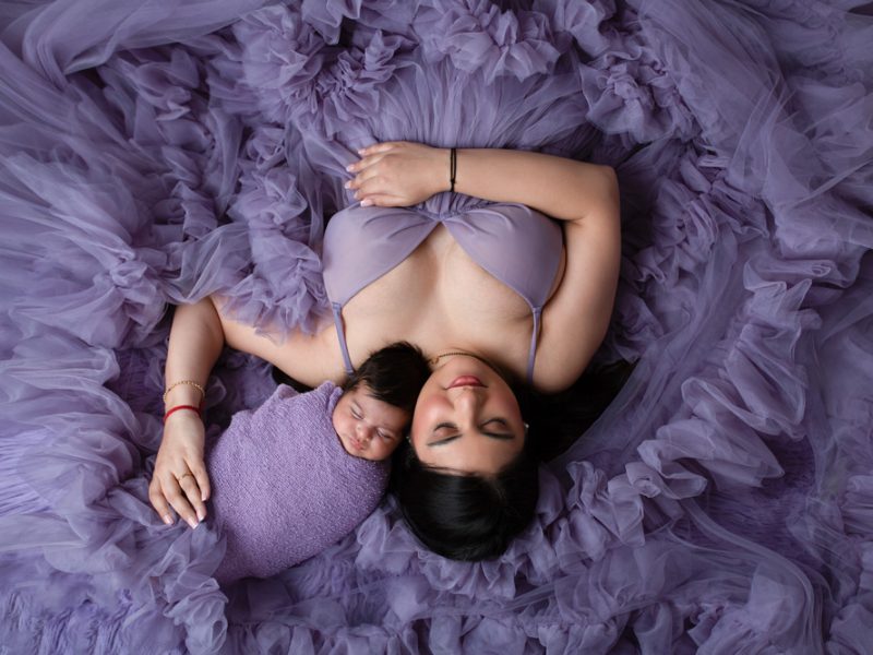 mum-laying-down-posed-with-newborn-baby-in-her-arms